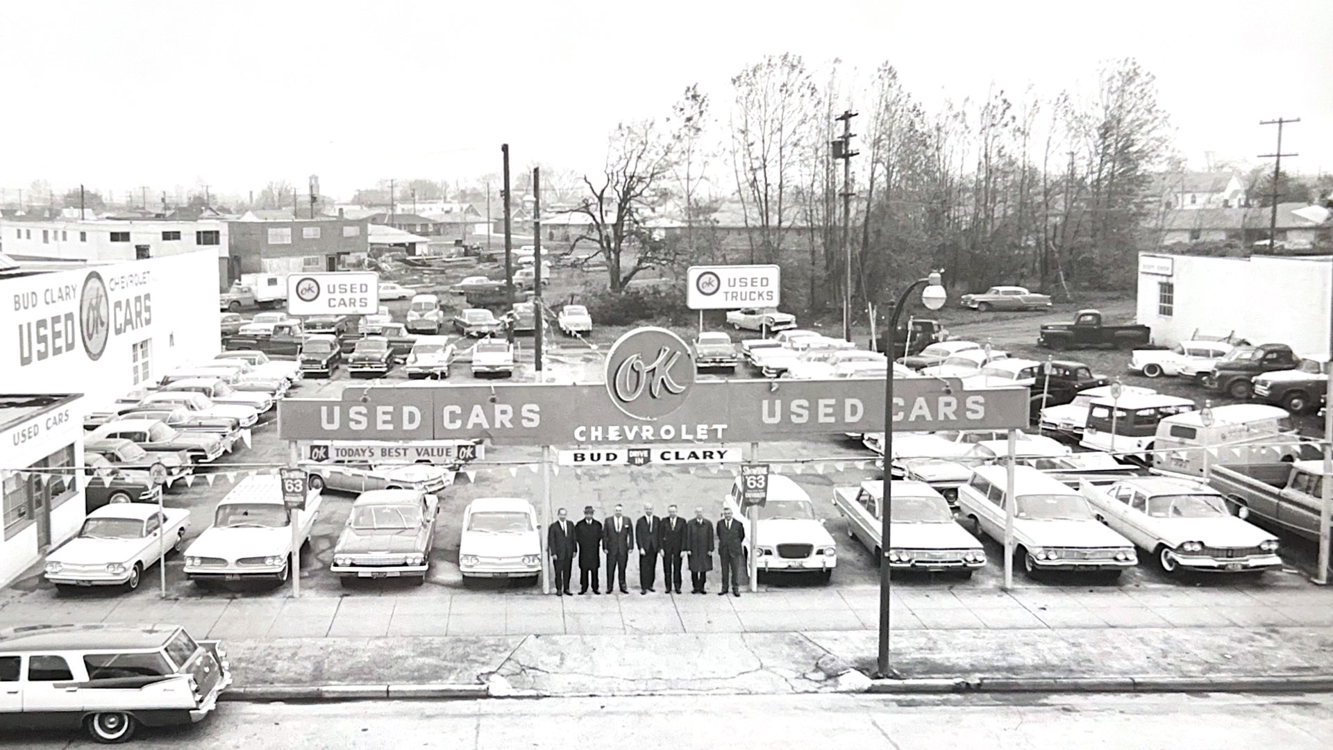 Historic Bud Clary dealership with owners standing in front